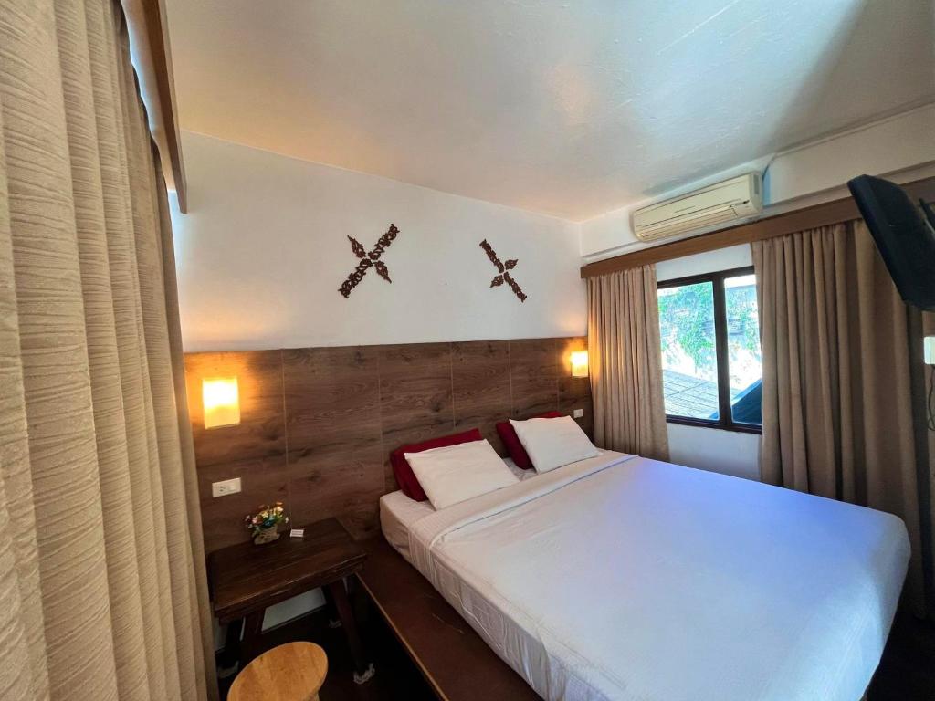 a bedroom with a bed and two crosses on the wall at Baan Rachaya in Chiang Mai