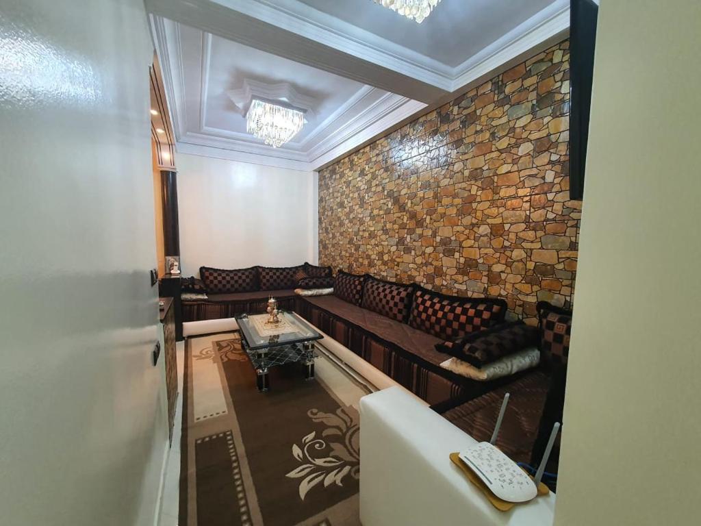 une chambre avec des canapés et un mur en briques dans l'établissement Residence Bouanane B, à Fès