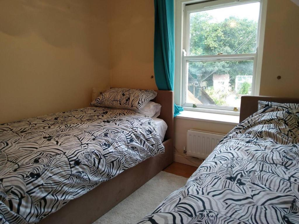 a bedroom with two beds next to a window at Gorgeous private apartment mesmerising sea views in Teignmouth