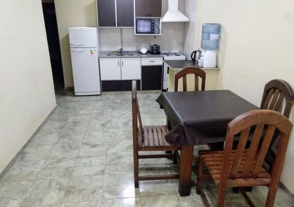 cocina con mesa, sillas y nevera en Departamento 5 en Puerto Iguazú