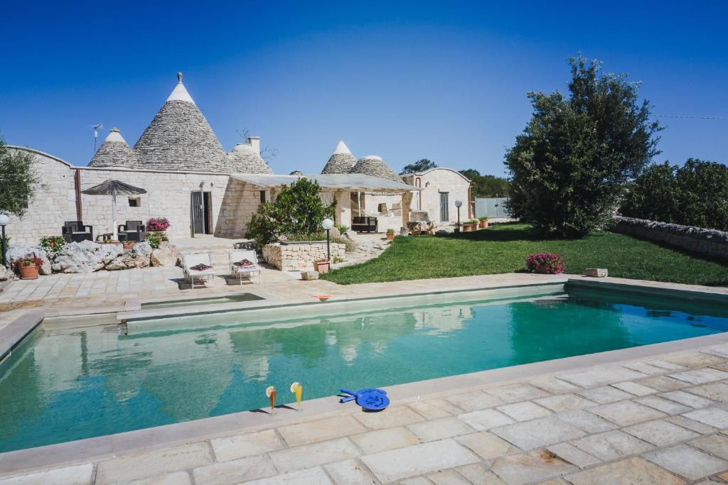 une grande piscine devant une maison dans l'établissement Trullo Narciso, à Alberobello