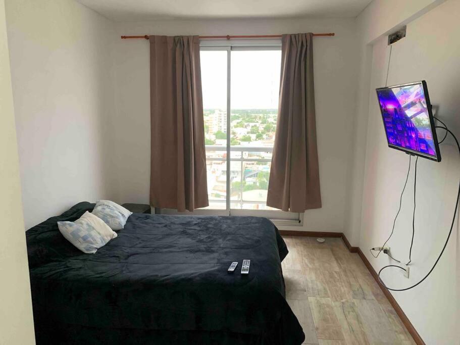 een slaapkamer met een bed, een televisie en een raam bij Dpto temporal amueblado con yacuzzi in San Lorenzo