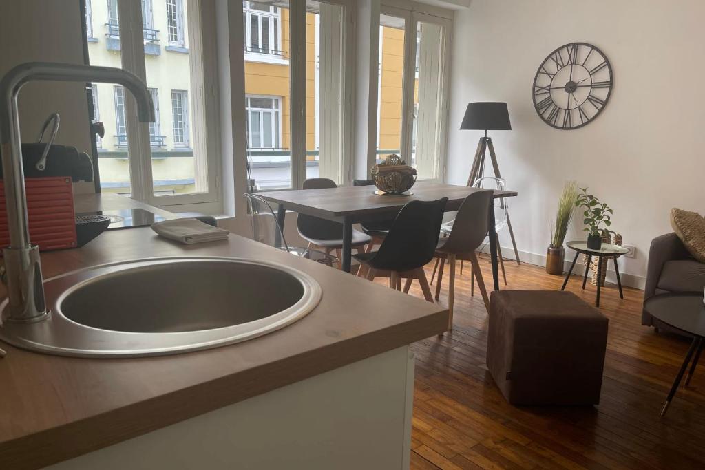 uma cozinha com um lavatório e uma mesa com cadeiras em Le Gambetta 4 - halles de Merville - T3 - centre ville em Lorient