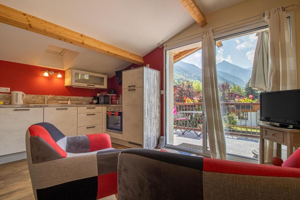 Il comprend une cuisine et un salon avec une grande fenêtre. dans l'établissement Le Nidouyé appartement 2 adultes UNIQUEMENT à Saint Lary Soulan, à Saint-Lary-Soulan