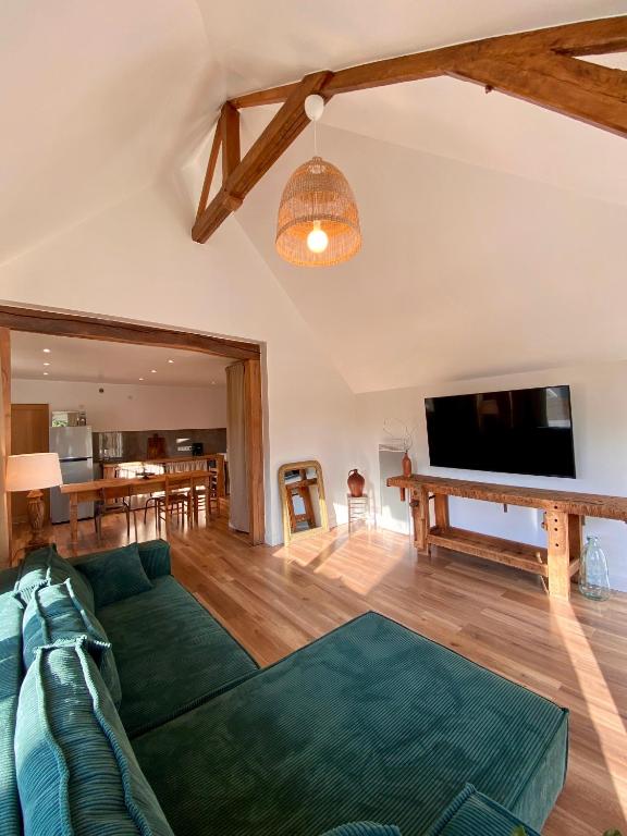 un salon avec un canapé et une télévision à écran plat dans l'établissement Maison calme et chaleureuse à la campagne, à Pont-sur-Seine