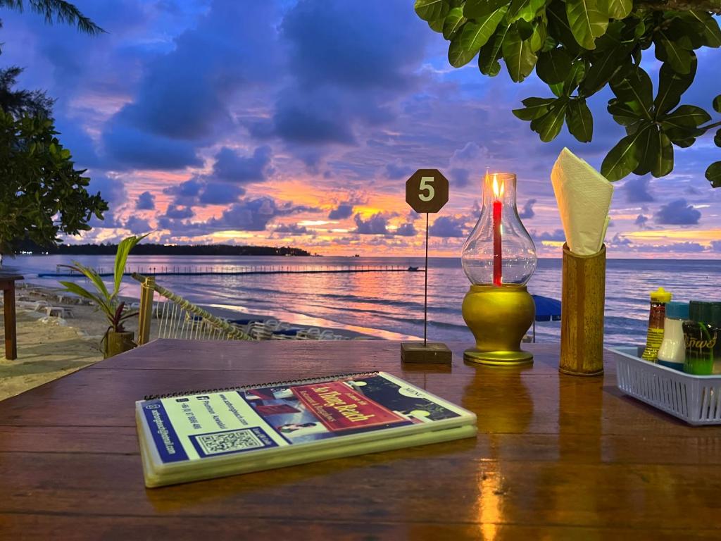 a table with a book and a lamp on it at Ao Thong beach Resort in Khao Lak