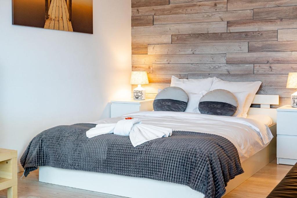a bedroom with a bed with a wooden accent wall at Lujerului Studio in Bucharest