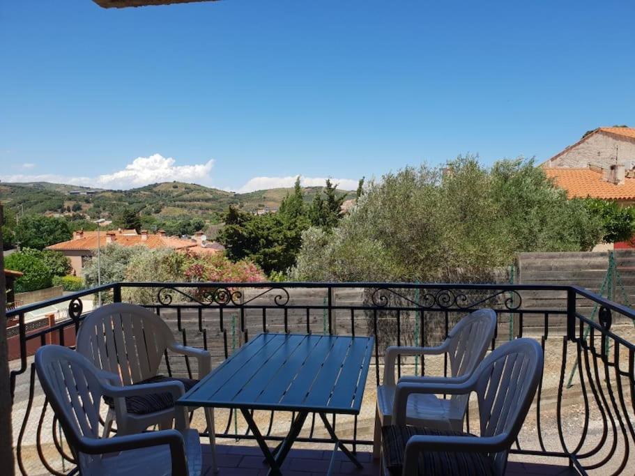 une table bleue et des chaises sur un balcon dans l'établissement Banyuls vu d'en haut : appartement T3 spacieux, à Banyuls-sur-Mer