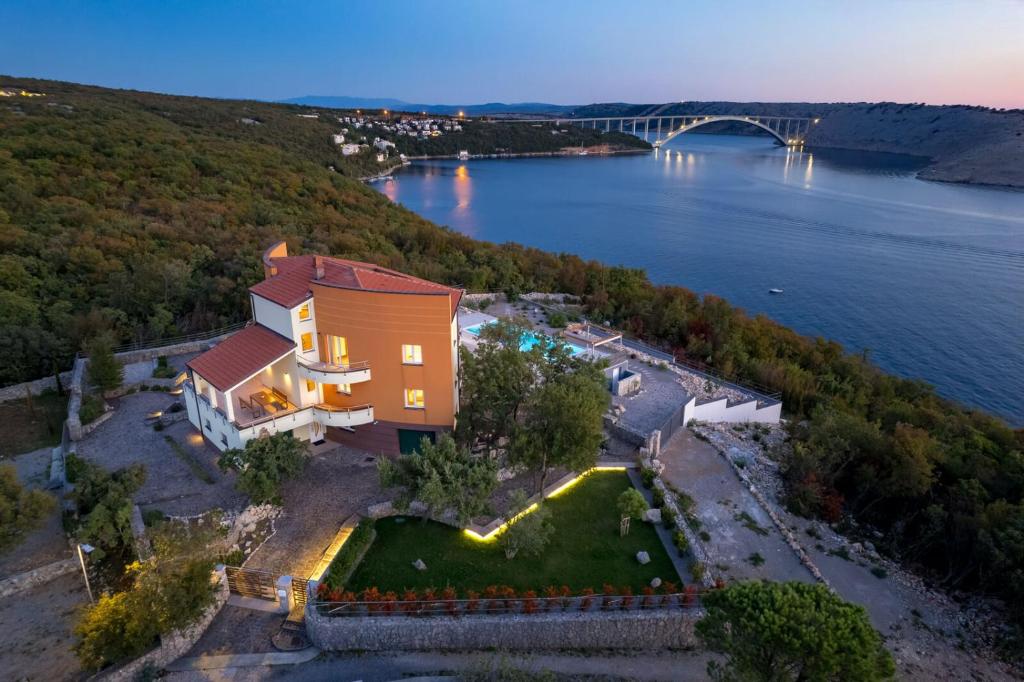 una vista aérea de una casa junto a un cuerpo de agua en Luxury Villa Oštro with pool, en Kraljevica