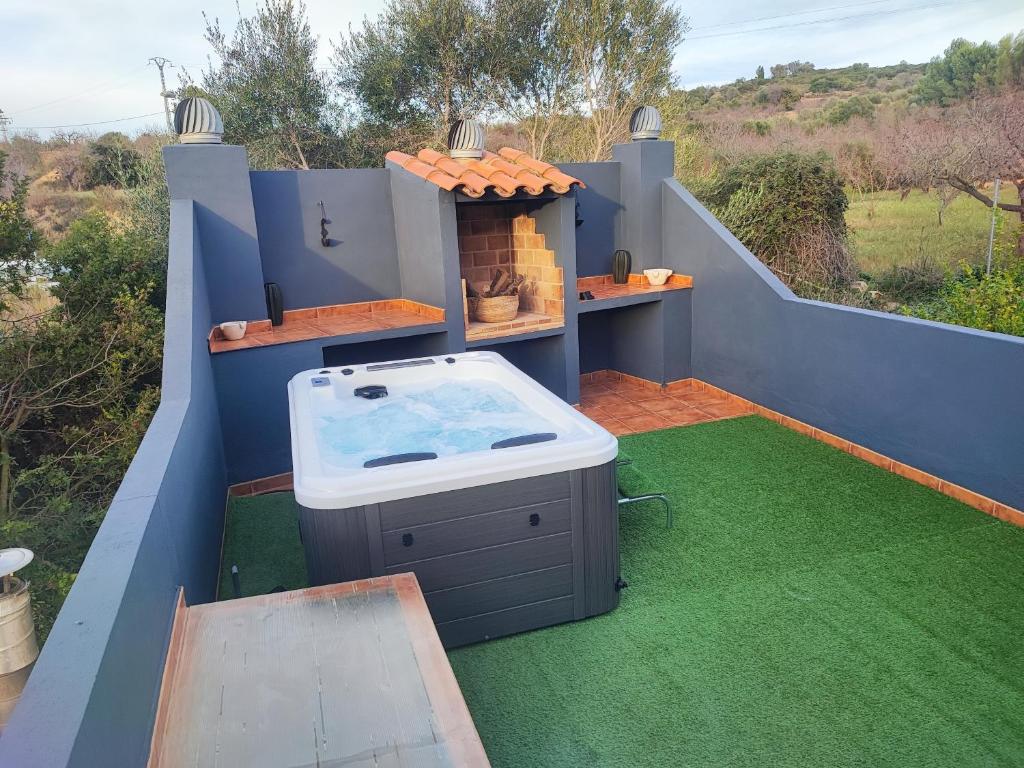 un bain à remous sur un balcon avec de l'herbe verte dans l'établissement Casa vacacional Lavernia, à Cabanes