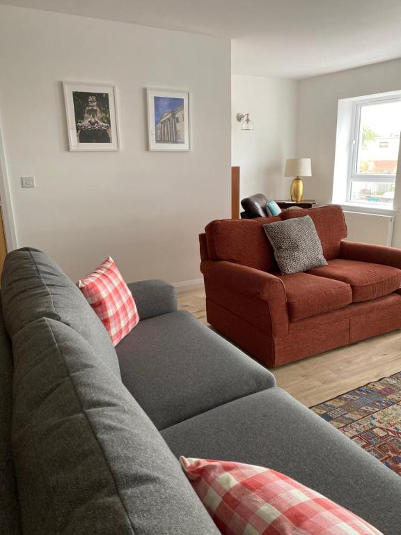 a living room with a couch and a red chair at Island town Apartment in Enniskillen