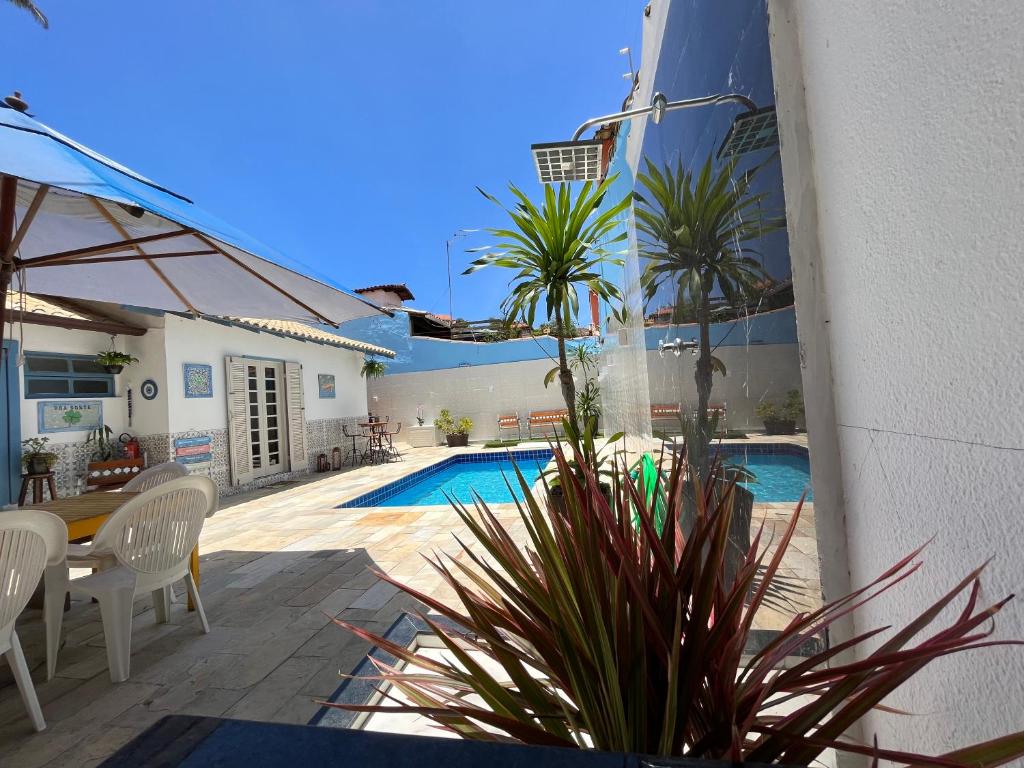 a patio with a pool and a table and chairs at BOA SORTE SUITES com PISCINA, GARAGEM GRATIS e Pé na PRAIA de GERIBÁ in Búzios