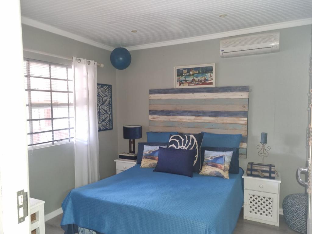 a bedroom with a blue bed and a blue balloon at Whispering waves in Gamtoosriviermond