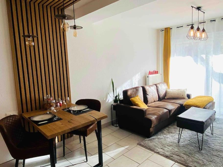 ein Wohnzimmer mit einem Sofa und einem Tisch in der Unterkunft L‘atelier in Châtenois