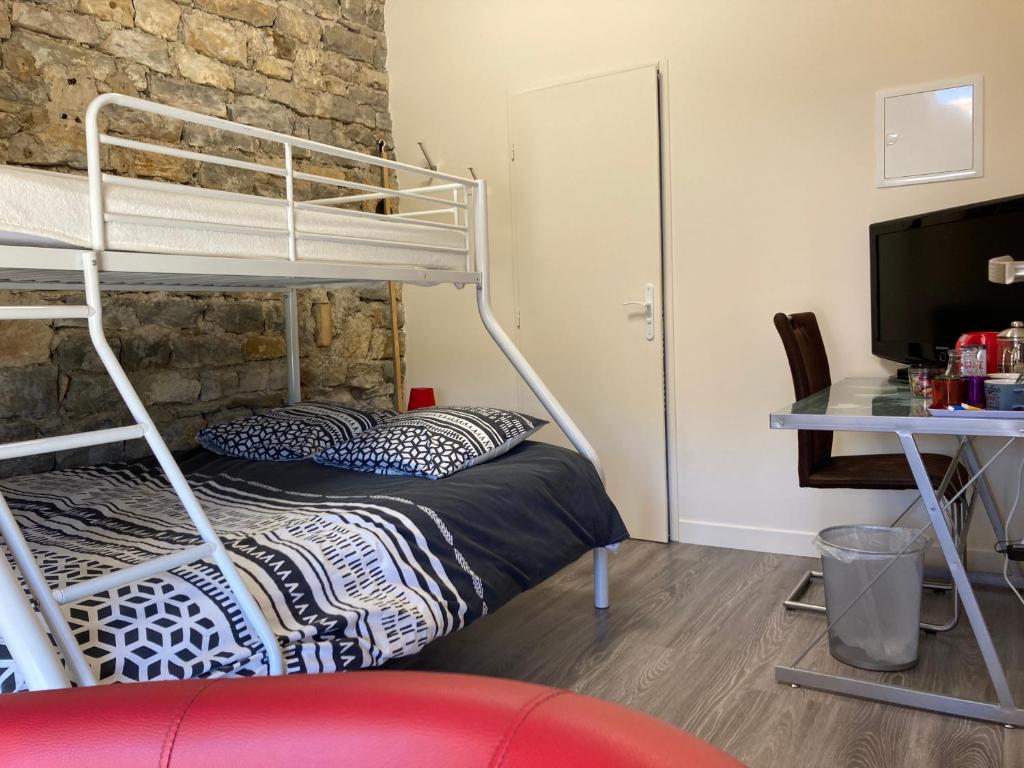 ein Schlafzimmer mit einem Etagenbett und einem Schreibtisch in der Unterkunft La Chambre du Tonneau in Montigny-sur-lʼAin