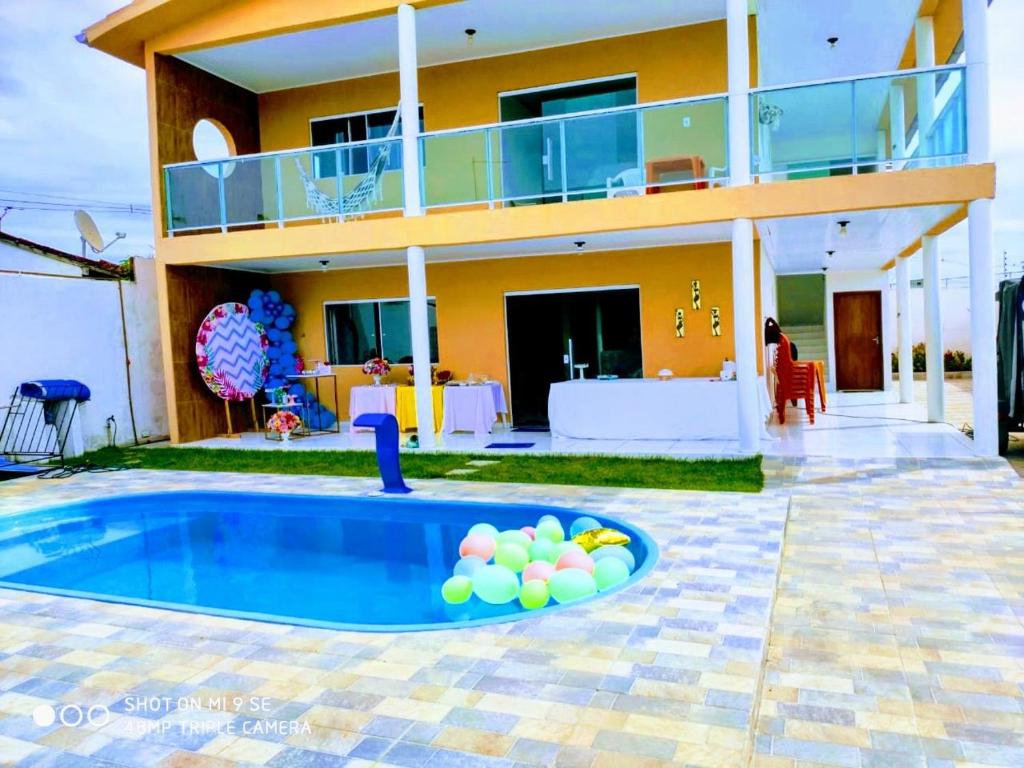 una casa con piscina frente a una casa en Aconchegante casa de praia em Paripueira/AL, en Paripueira