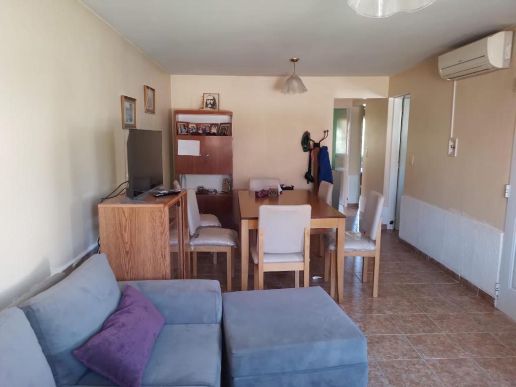 a living room with a couch and a dining room table at Casa en Barrios Los Arcos in Plottier