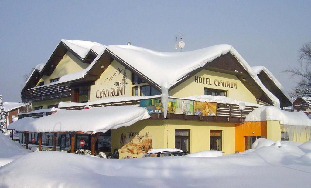 a building with snow on top of it at Hotel Centrum Harrachov in Harrachov