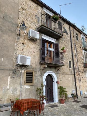 ein altes Gebäude mit einem Tisch und einem Balkon in der Unterkunft casa sulla roccia in Sperlinga
