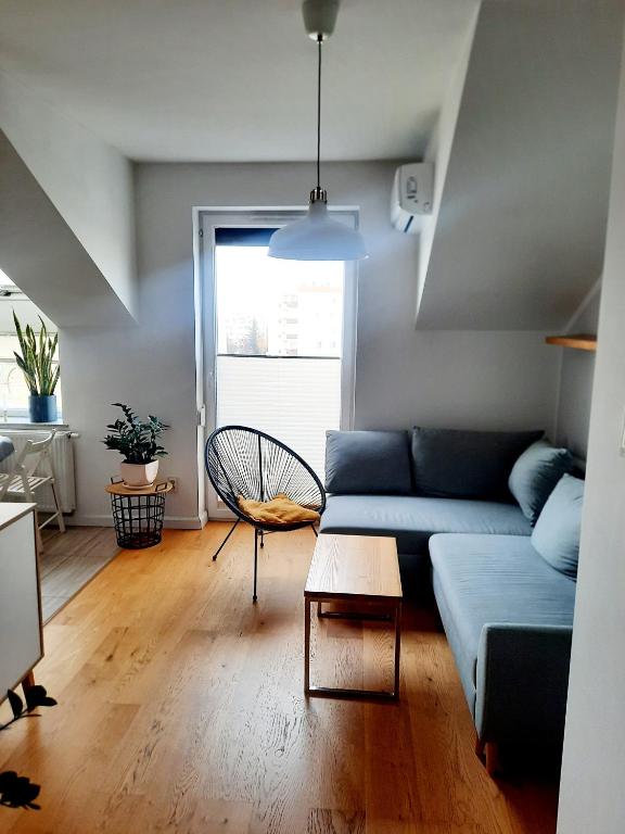ein Wohnzimmer mit einem blauen Sofa und einem Tisch in der Unterkunft Apartament 252 in Kielce