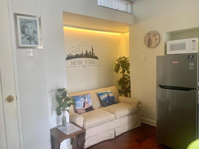 a living room with a couch and a refrigerator at Lindos Apartamentos en San Isidro in Lima