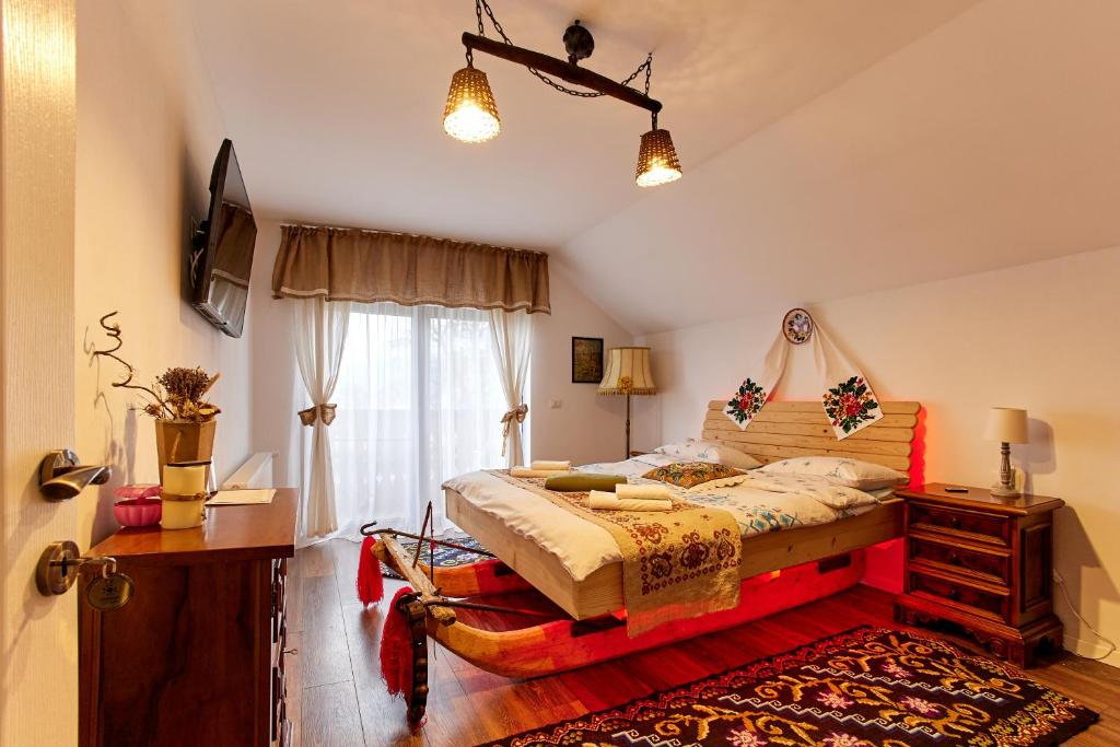 a bedroom with a large bed and a window at Gradina Lu' Ion - Adults Only in Vişeu de Sus
