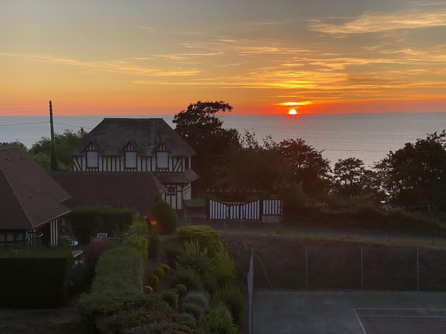 une maison avec le coucher du soleil en arrière-plan dans l'établissement Appart lumineux avec vue sur mer à 180 degrés, à Trouville-sur-Mer