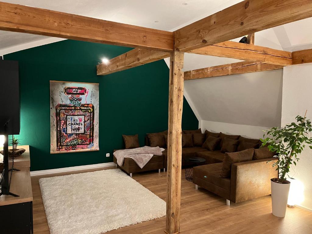 uma sala de estar com paredes verdes e um sofá em Super Lodge Kulmbach em Kulmbach