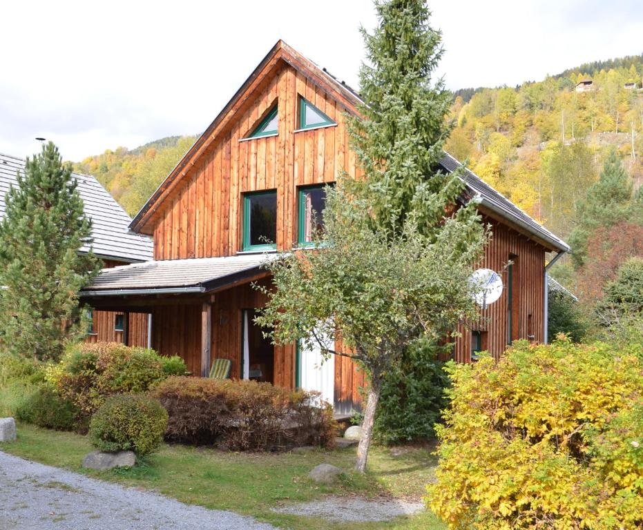 ein Holzhaus mit einem Baum davor in der Unterkunft Ferienhaus Kreischberg in Sankt Lorenzen ob Murau