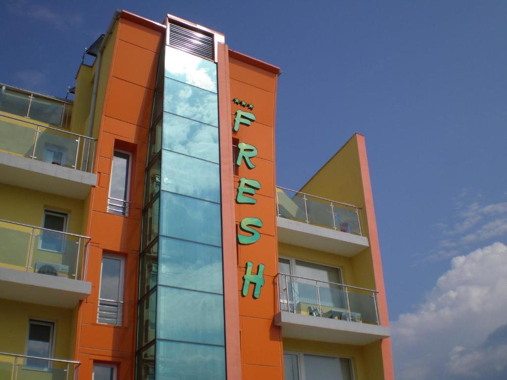 an orange building with a sign on the side of it at Fresh Family Hotel in Ravda