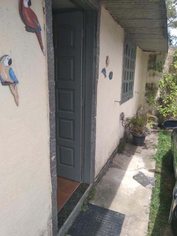 una puerta a una casa con pájaros en la pared en Casa dos passarinhos, en Arraial do Cabo