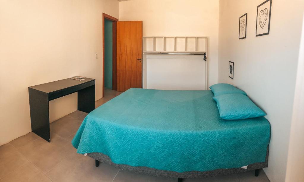 una piccola camera con letto e tavolo di Kitnet em Imbituba - Fabi a Imbituba