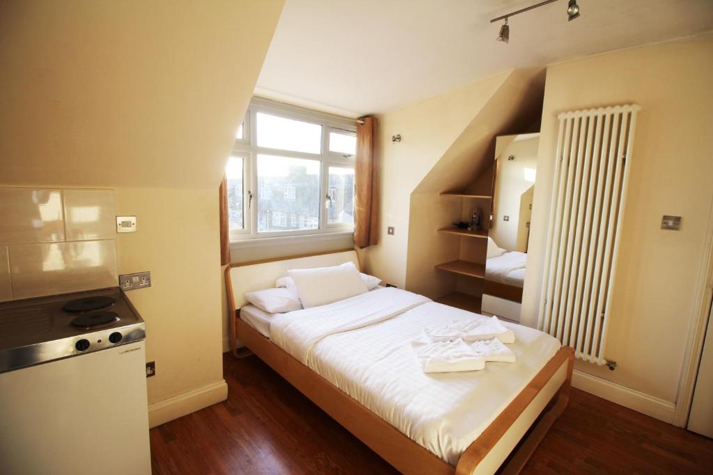 a small bedroom with a bed and a window at Flexistay Tooting Studios in London