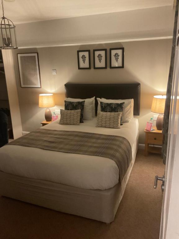 a bedroom with a large bed with three pictures on the wall at Oak Tree Lodge & Holiday Parking in Burstow