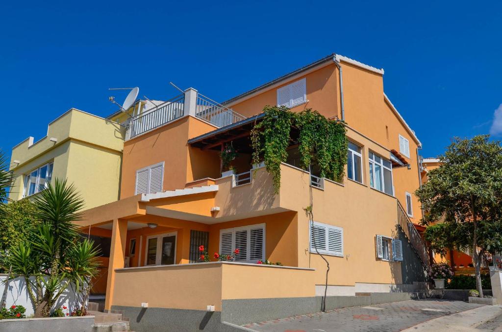 un gran edificio naranja con plantas. en Apartments Karla, en Orebić