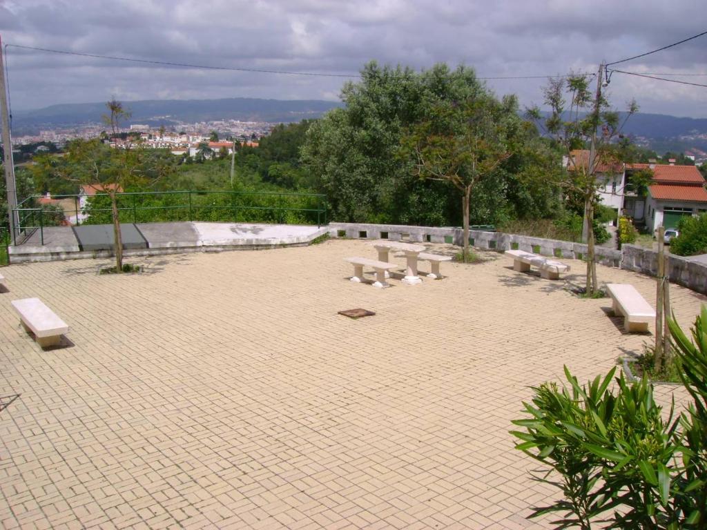 a group of benches sitting on a brick patio at Casa da Tia Lena in Coimbra