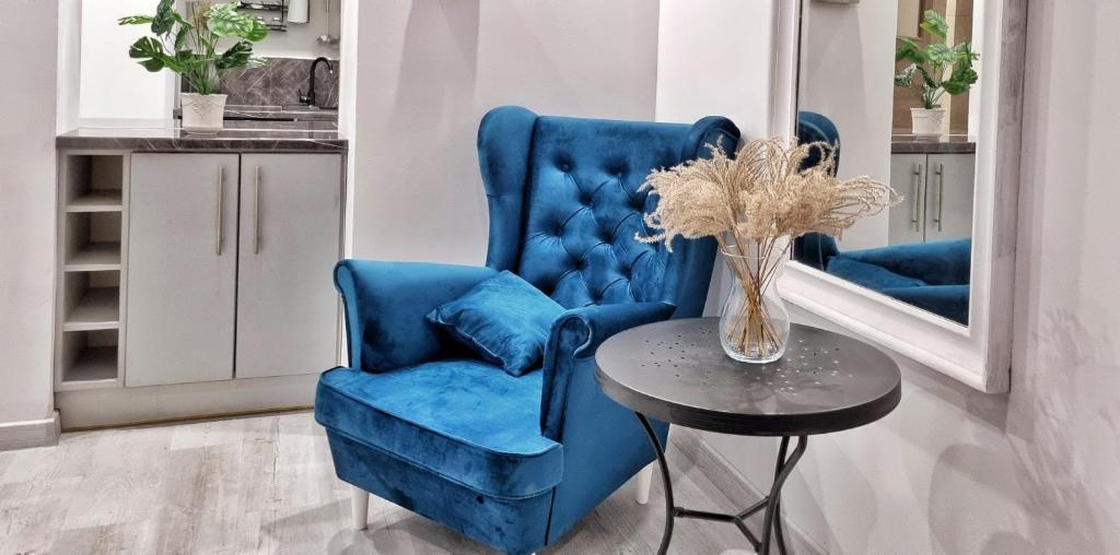 einen blauen Stuhl und einen Tisch in einem Zimmer in der Unterkunft Apartament Kaczyniec 10 in Gliwice