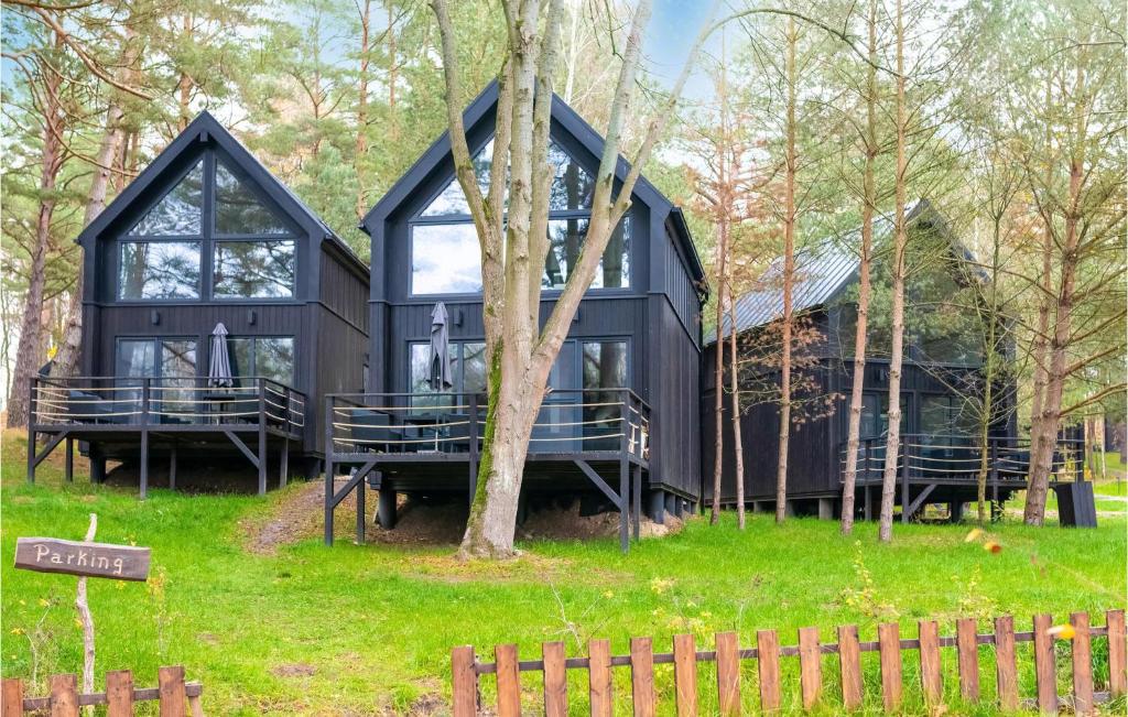 a black house in the middle of the forest at Beautiful Home In Frombork With Outdoor Swimming Pool, Sauna And Wifi in Frombork