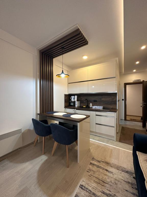 una cucina con tavolo e sedie in una stanza di Apartman Holiday a Kopaonik