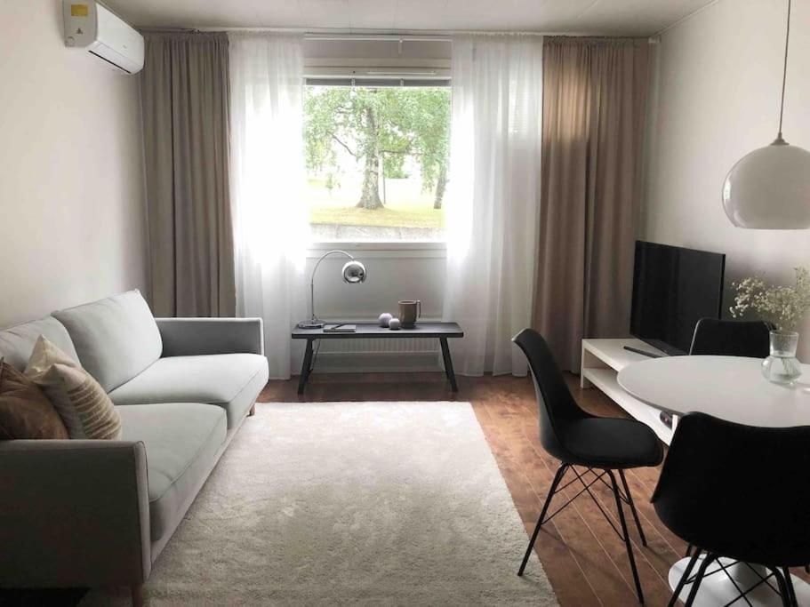 a living room with a couch and a table at Lovely two room unit with free parking in Kuopio