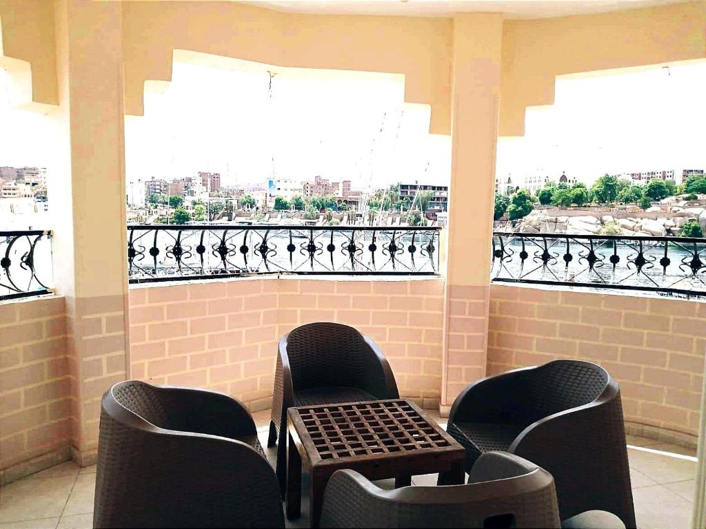 a balcony with two chairs and a table and a window at Winji Guest house in Aswan