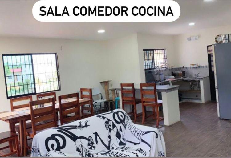 a room with a table and chairs and a kitchen at Estancias De Olon in Olón