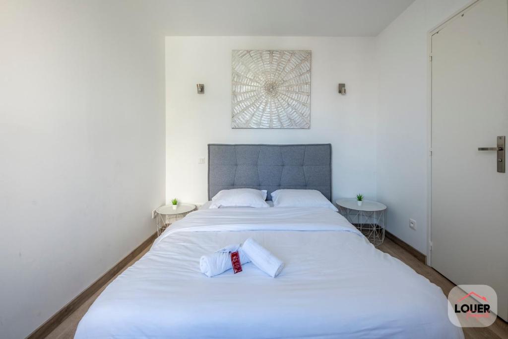 ein weißes Schlafzimmer mit 2 Betten und einem Fenster in der Unterkunft Dolmen 4 Calme et Confortable Tours in Tours