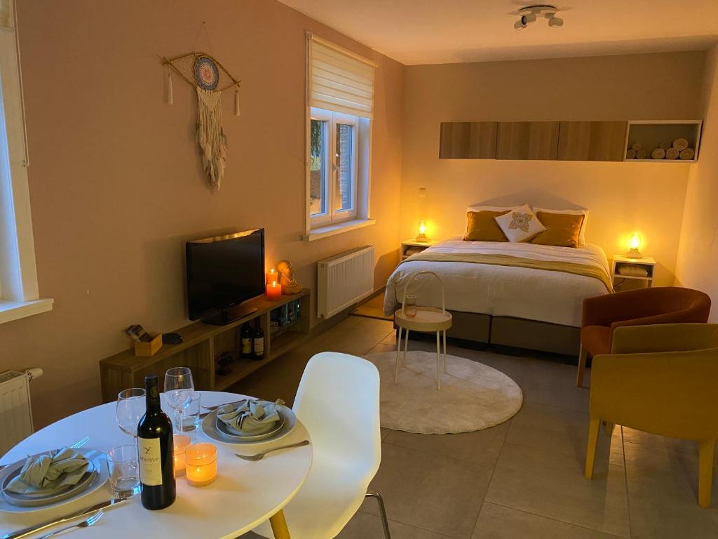 1 dormitorio con 1 cama, mesa y sillas en Vakantiestudio Ouanaïo, en Zedelgem