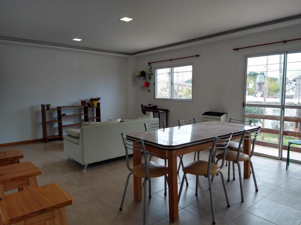 sala de estar con mesa de madera y sillas en Nuestra Casa en el Mar en Mar de Ajó