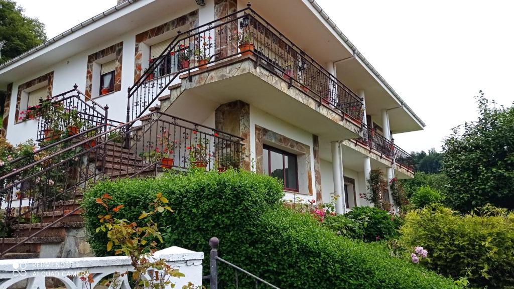 biały budynek z balkonami i kwiatami w obiekcie Casa el rey 12 - Apartamentos Buenos Aires y Figueras AR-1419-AS w mieście Valbona