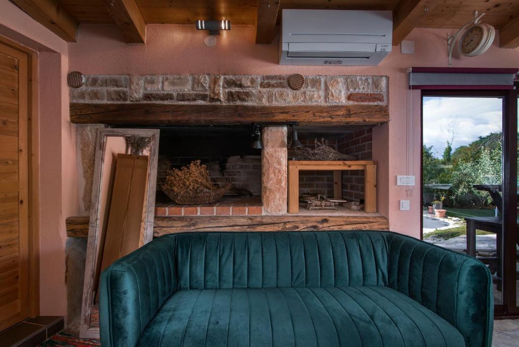 a green couch in a room with a fireplace at Istrian Tavern next to the Pool in Banjole