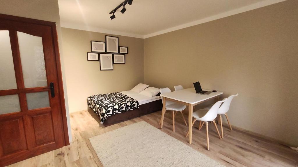 a bedroom with a bed and a table with a laptop at Studio, Kraków - Czyżyny in Kraków