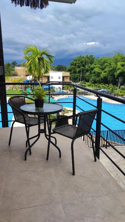 un patio con mesa y sillas junto a una piscina en Apartamento de verano cerca al parque del café en La Tebaida