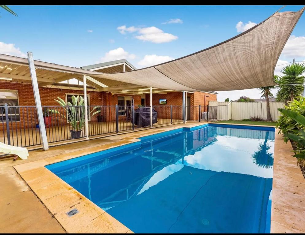 una piscina con dosel sobre una casa en Modern family home with pool, en Carisbrook